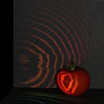 red apple with dark background and wavy lines of light across the scene