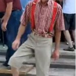dancing elderly man white beard red shirt suspenders and different colored socks