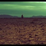 dry parched earth in foreground greenish sky above