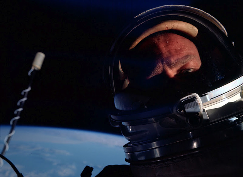 Close up of astronuat's face in helmet earth in background