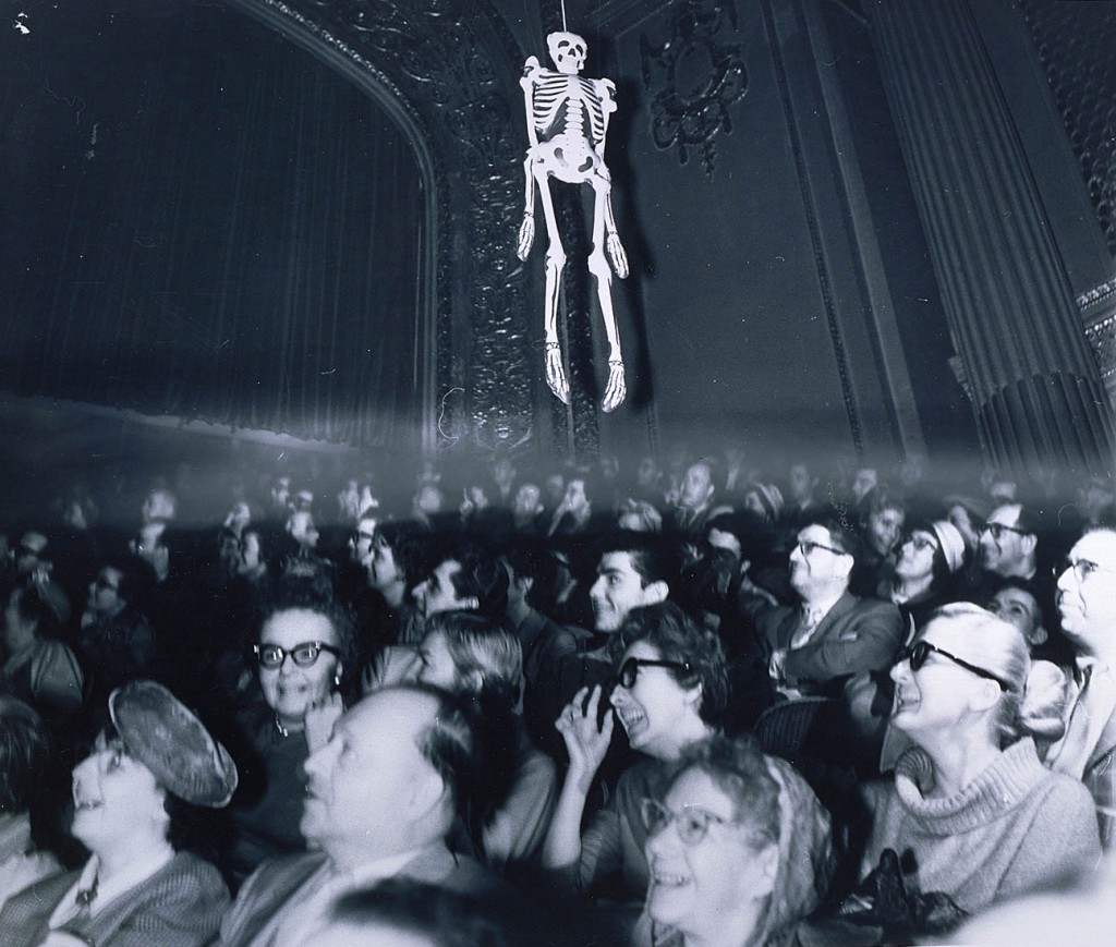 People watching Haunting of Hill House in 1950 movie theater, skeleton hangs from ceiling.