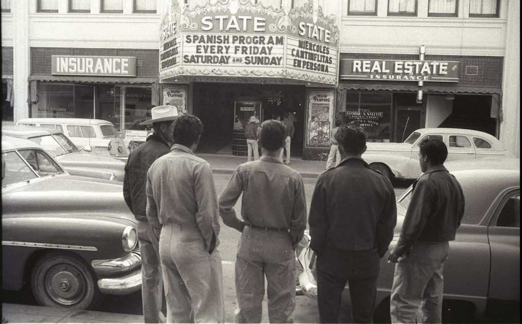 Men stand across from movie theater marquee in 1956, photographer Leonard Nadel